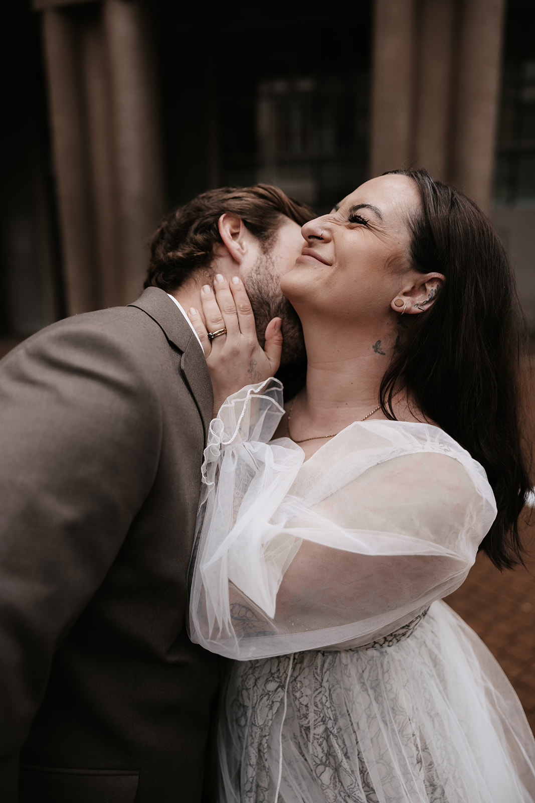 Groom whispering into the bride’s ear, making her smile during a playful moment in their Vancouver elopement.