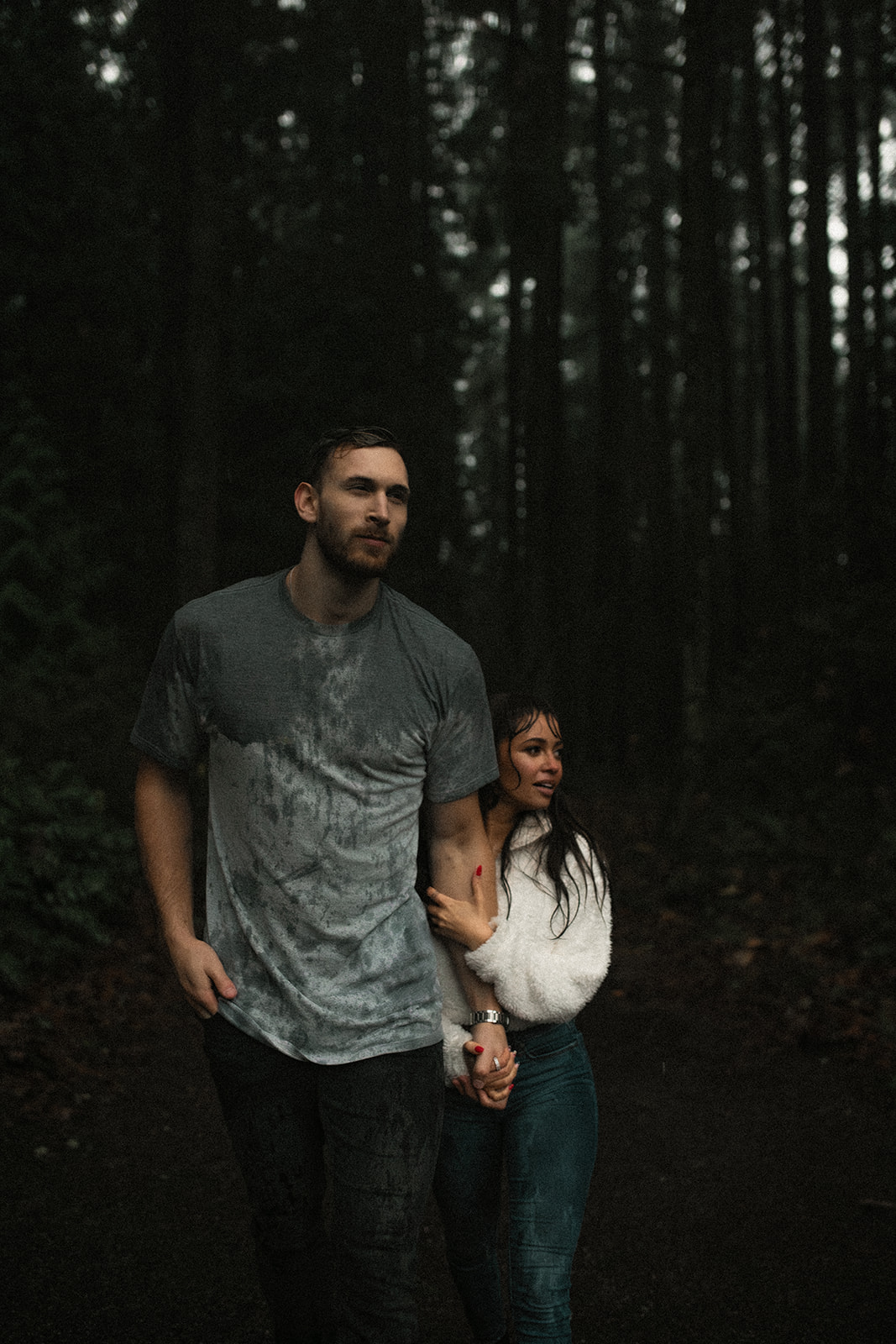 The couple walking through a misty forest, hand in hand, as the rain creates a dreamy atmosphere. This rainy day couple picture highlights their connection and the adventurous side of fun couple photoshoot ideas.