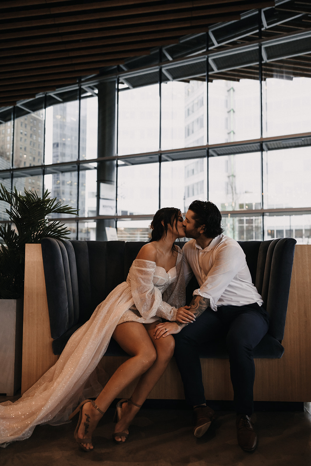 Bride and groom kissing as they are sitting in a hotel in Vancouver