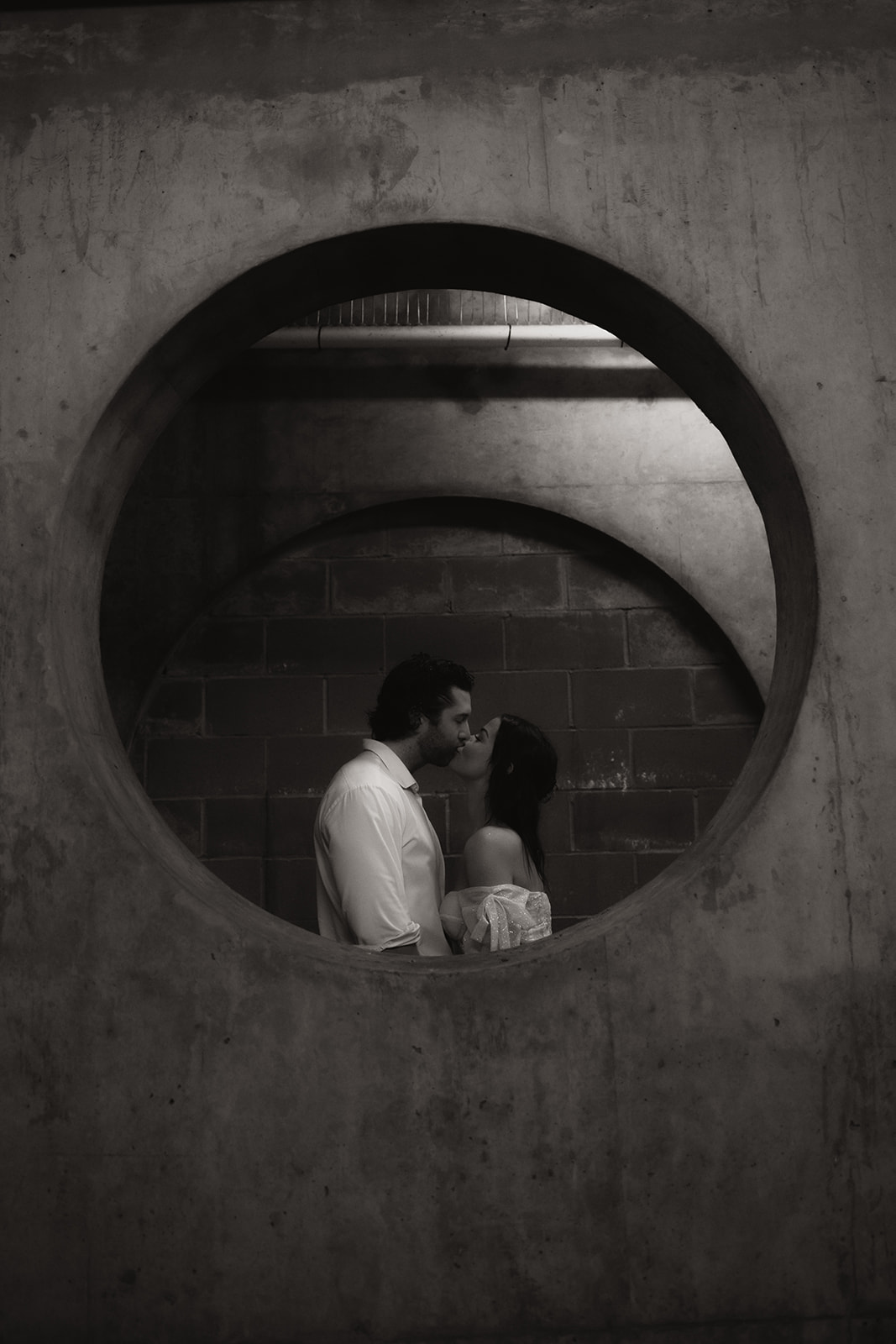 Bride and groom kissing in a underground parking garage