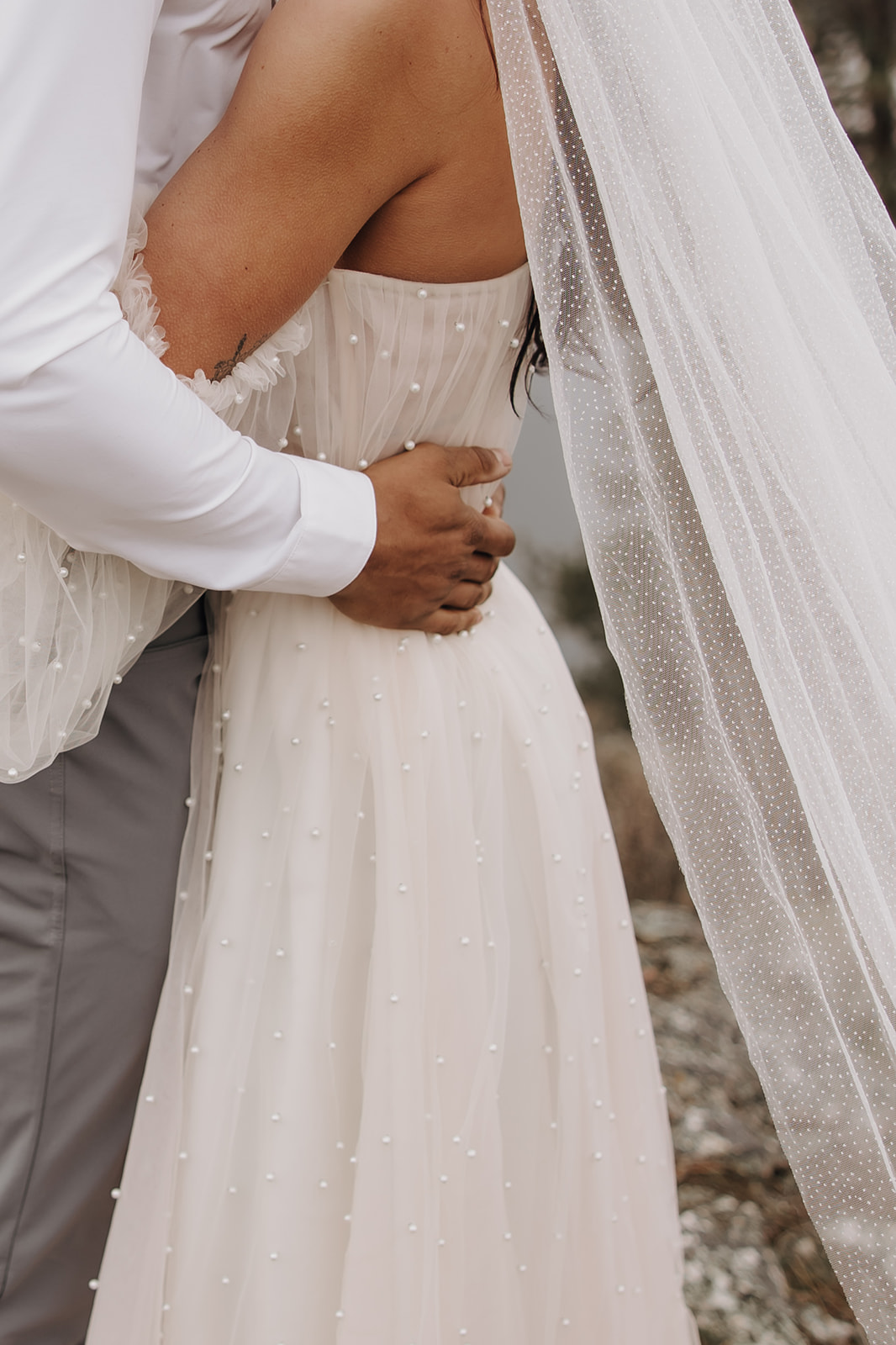 Groom holding brides waste in a strapless elopement dress