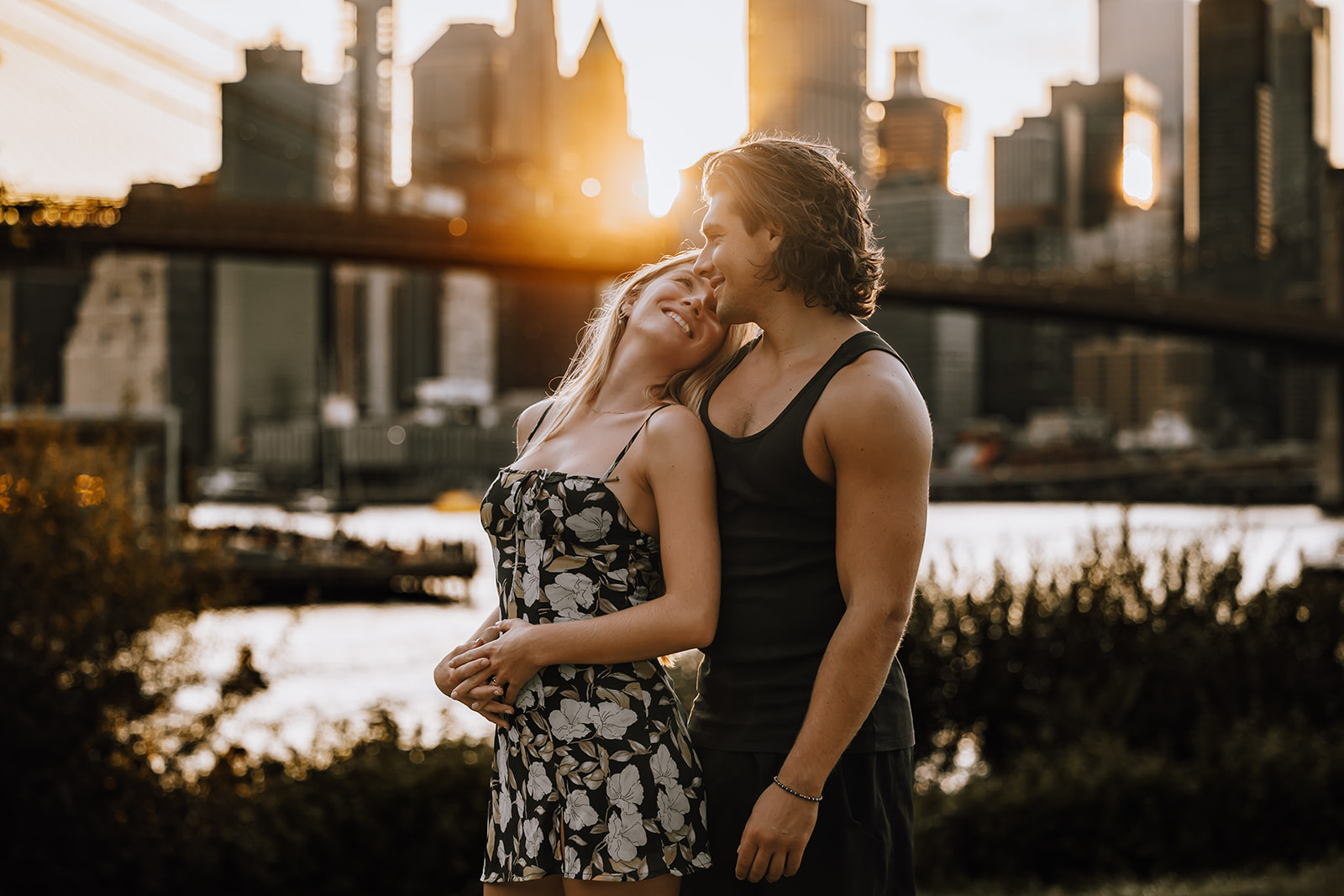 A beautiful sunset moment with the couple standing close together, their love glowing as they enjoy their new york city couple photoshoot by the waterfront.