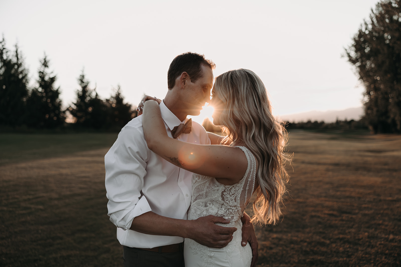 Romantic sunset portrait of the bride and groom at their Redwoods Golf Course wedding, with the golden hour light creating a warm glow.