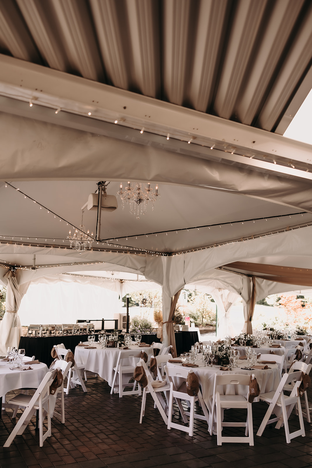 Wide shot of the reception area at the Redwoods Golf Course wedding venue, featuring tables, string lights, and a charming atmosphere.