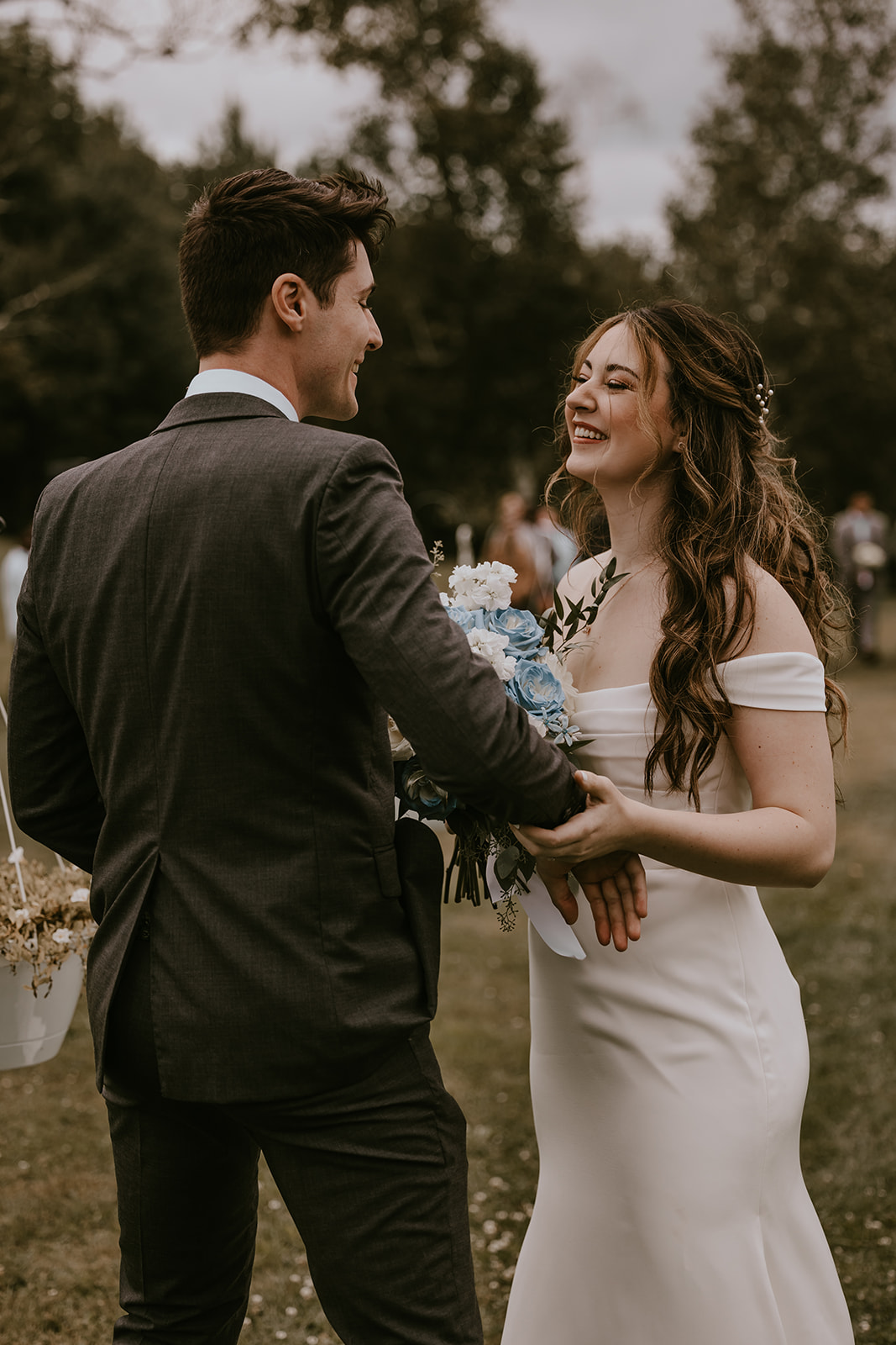 Bride and groom holding hands smiling at eachother