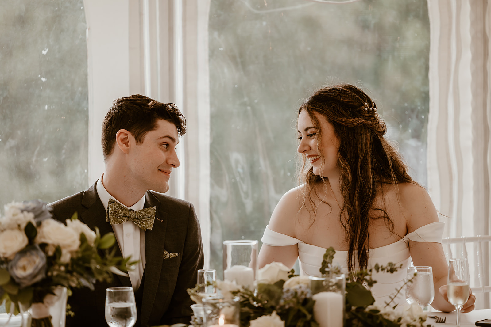 Bride and groom smiling at one another during their wedding reception