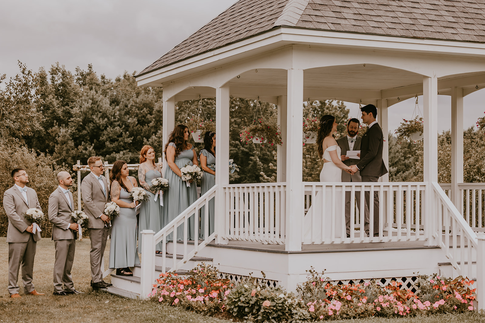 The couple exchanges vows at the picturesque gazebo during their destination wedding in Maine, with a stunning view of nature behind them at Lucerne Inn.