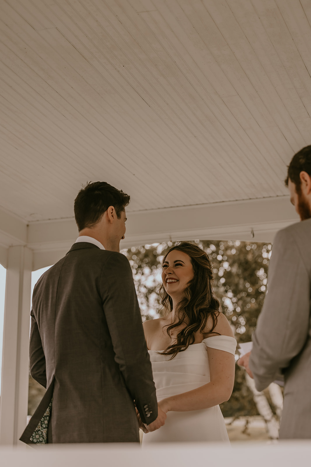 A close-up of the couple sharing an intimate moment during their destination wedding in Maine, captured under the gazebo at Lucerne Inn, with smiles that speak volumes