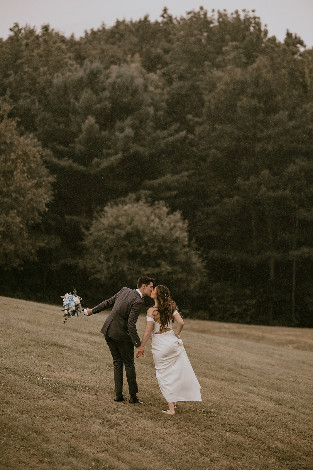 The newlywed couple walks across the scenic Maine landscape at Lucerne Inn, hand in hand, reflecting the magic of their destination wedding in Maine.