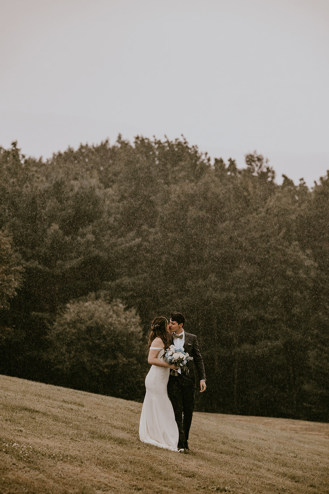 Bride and groom enjoying the rain together, walking hand in hand at the Lucerne Inn, an intimate and memorable moment from their destination wedding in Maine.