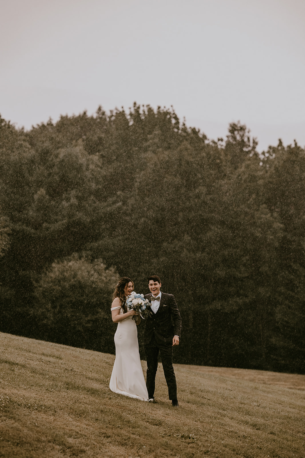 Bride and groom enjoying the rain together, walking hand in hand at the Lucerne Inn, an intimate and memorable moment from their destination wedding in Maine.