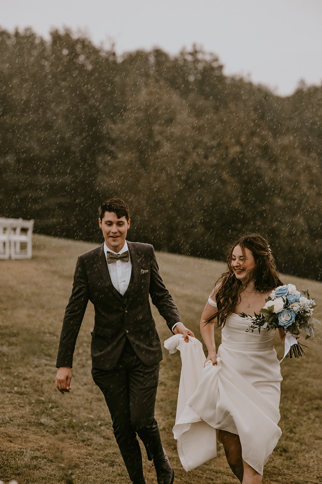 Bride and groom enjoying the rain together, walking hand in hand at the Lucerne Inn, an intimate and memorable moment from their destination wedding in Maine.