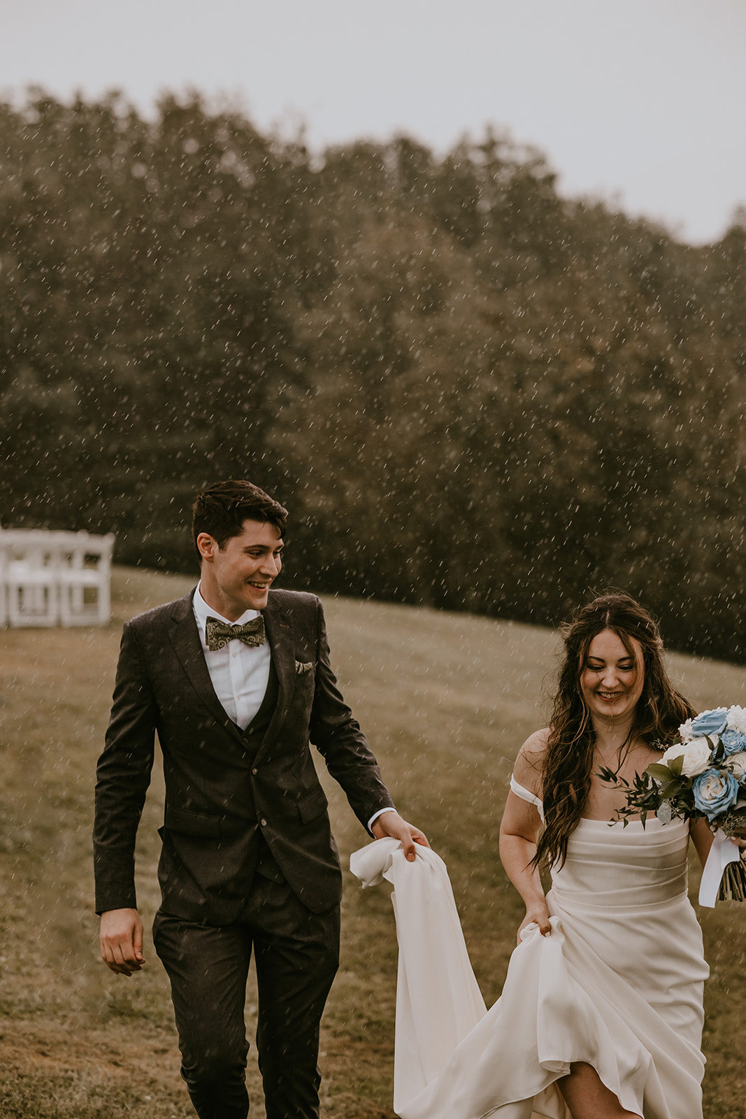 Bride and groom enjoying the rain together, walking hand in hand at the Lucerne Inn, an intimate and memorable moment from their destination wedding in Maine.