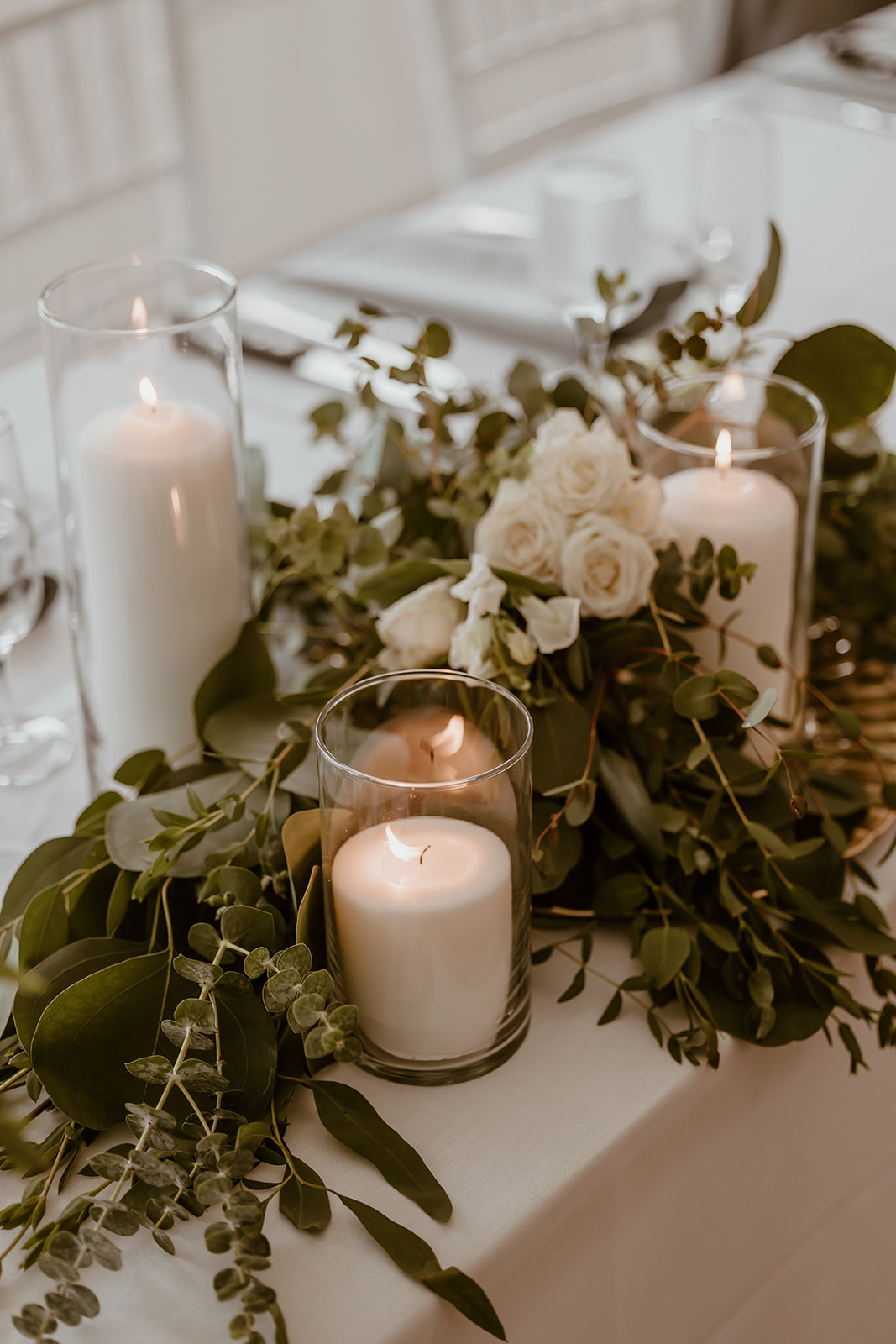 The elegant reception setup featuring beautiful floral arrangements and candles for a destination wedding in Maine, creating a warm and inviting atmosphere