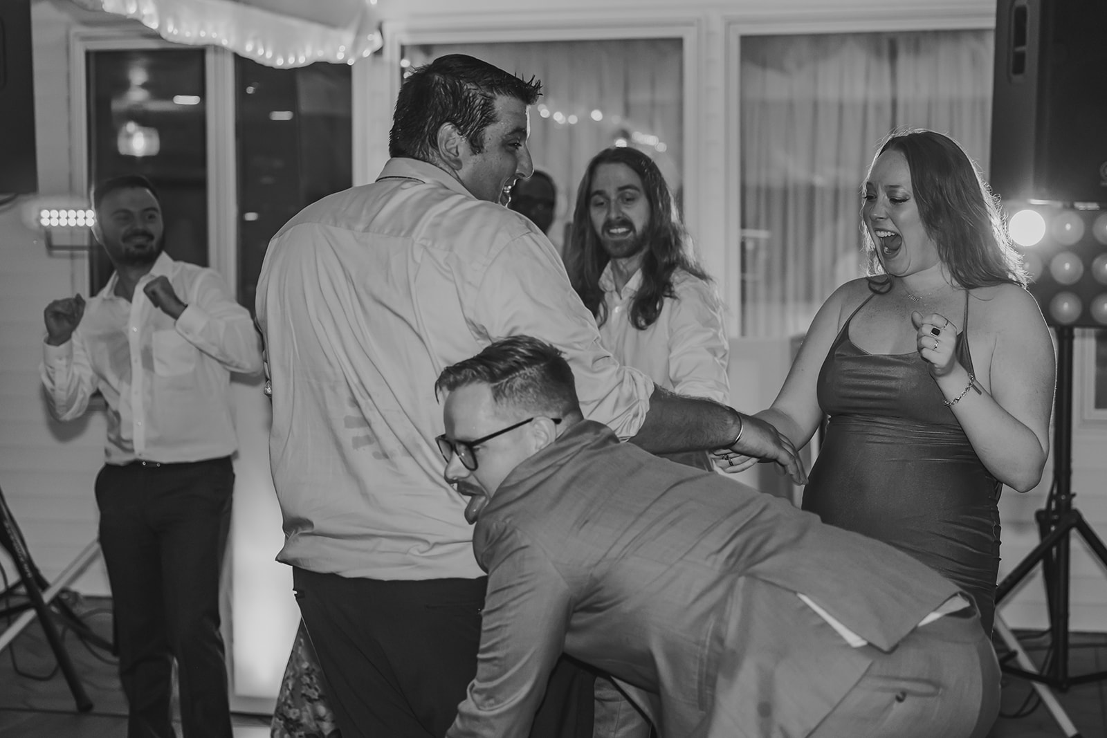 A candid moment of guests celebrating on the dance floor at the reception of this Maine destination wedding, capturing the joy and carefree atmosphere