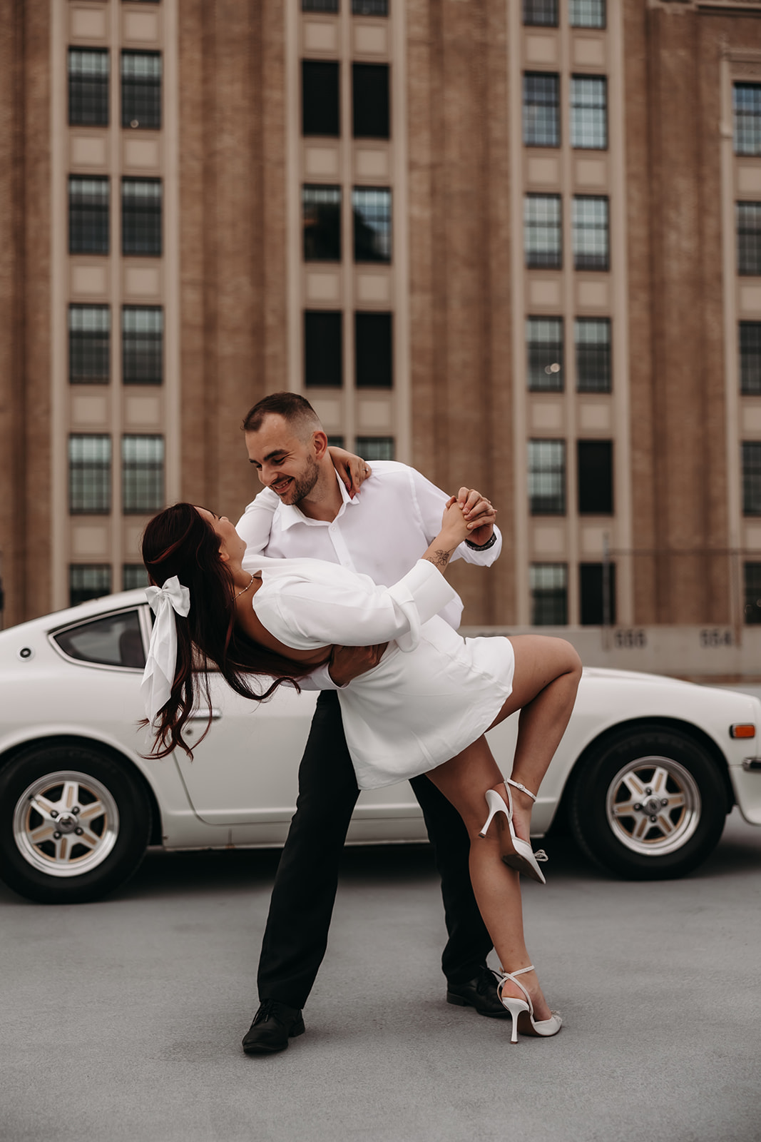 The couple sharing an intimate dip in the city engagement photos, framed by the bold lines of Vancouver’s cityscape.