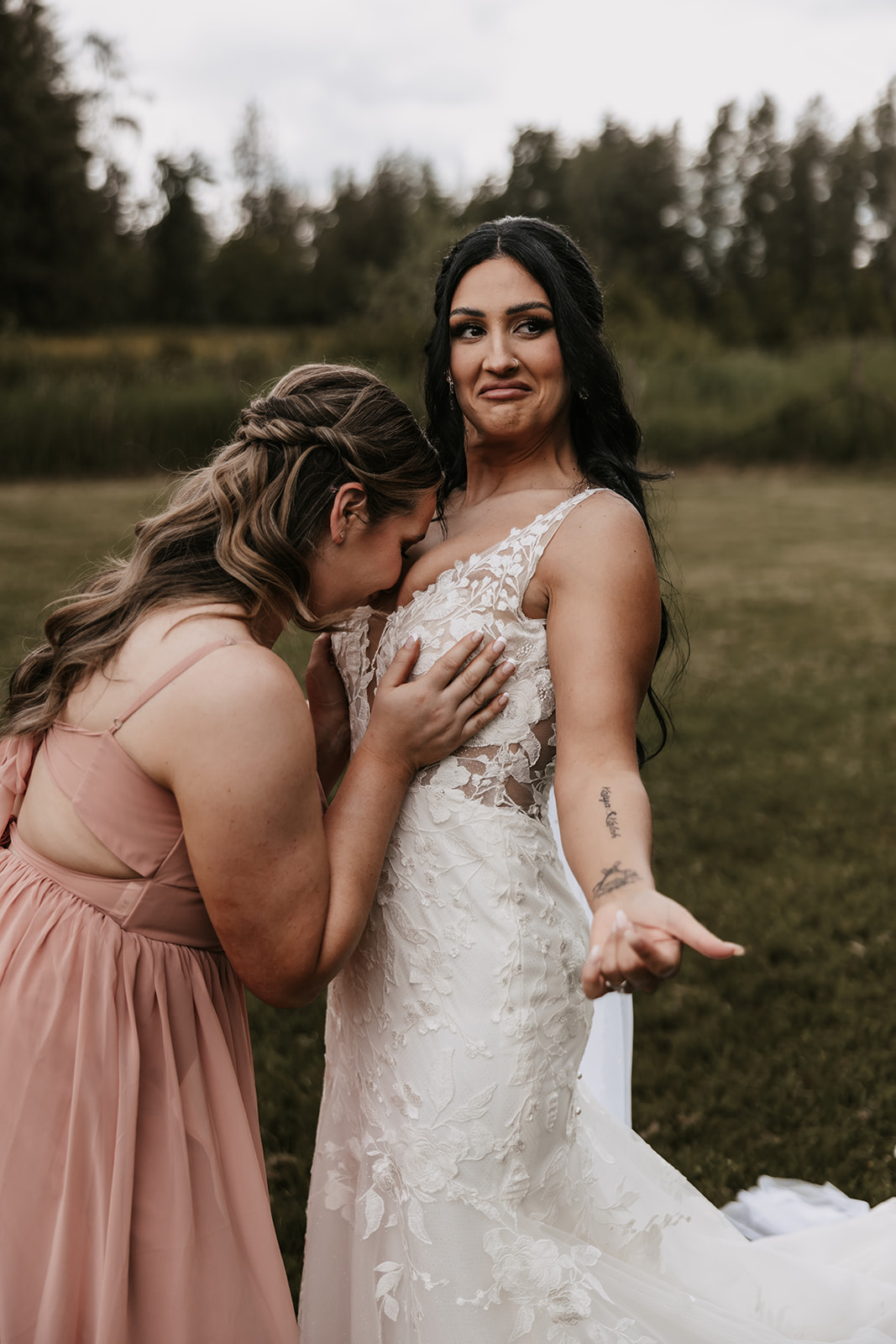 Bridesmaid adjusting the bride's dress with laughter, showing how much fun and joy can be found in even the small moments of the wedding day.