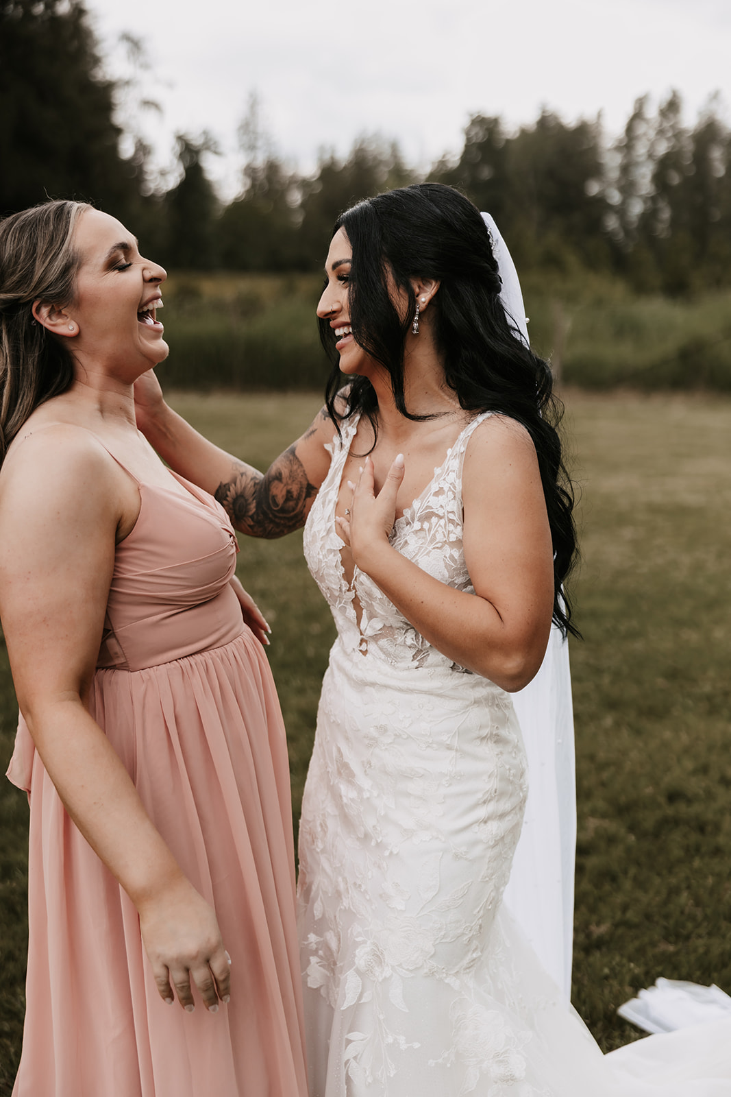 Bride and bridesmaid laughing with one another