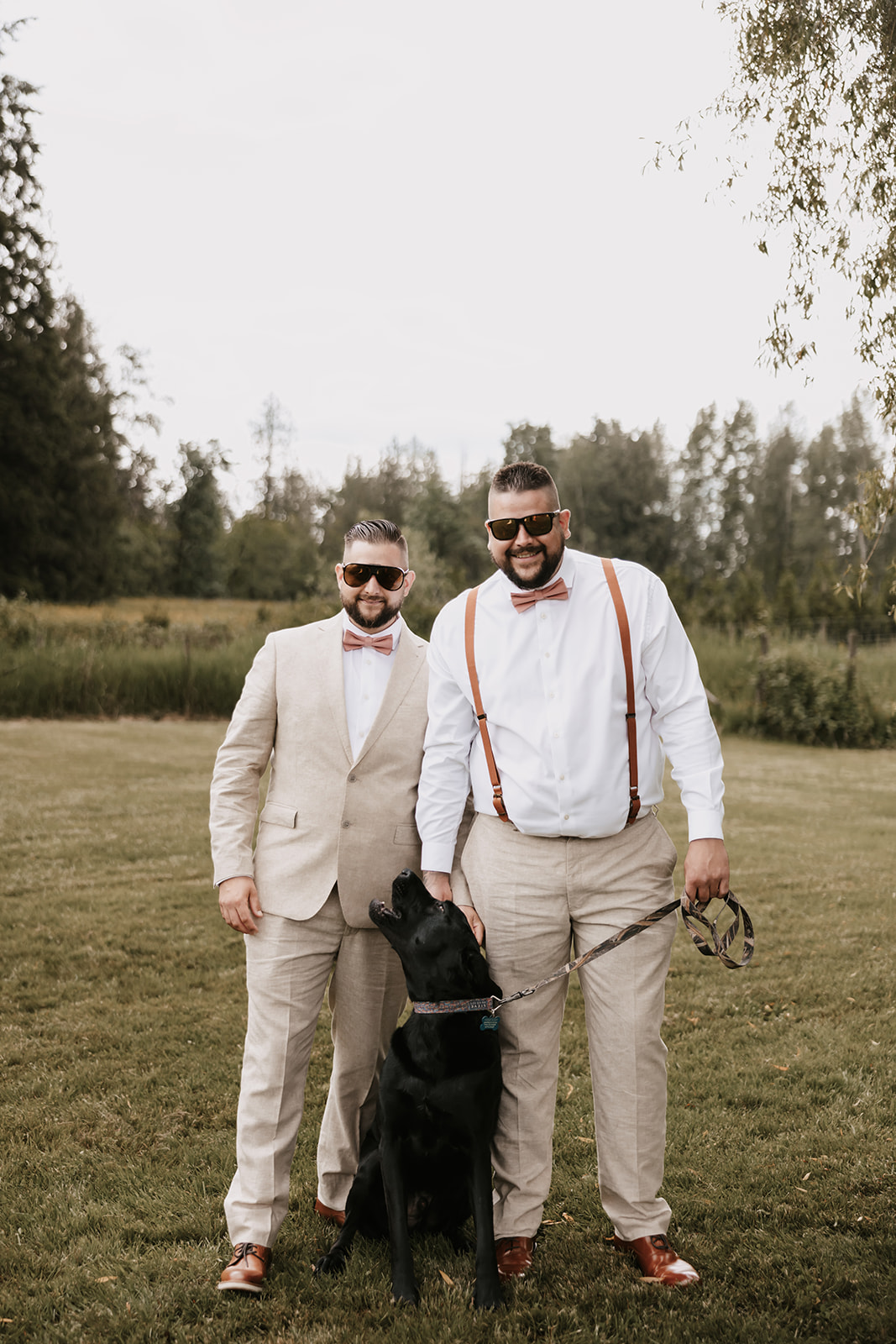 Groomsmen smiling and posing with the couple’s dog, highlighting the fun and playful vibe of the wedding day with a relaxed and joyful atmosphere