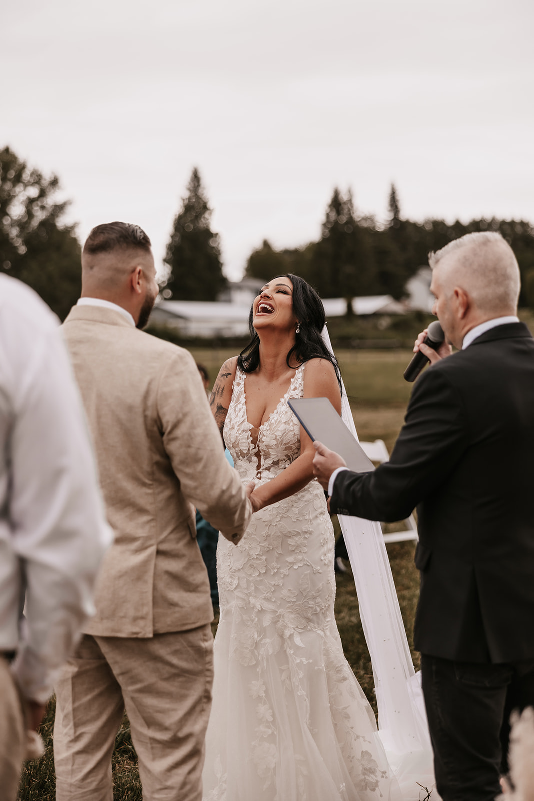 Bride and groom laughing together during their wedding ceremony. The bride looks at her partner joyfully as they share vows. Moments like these are the key to knowing how to enjoy your wedding day, by focusing on each other and the emotion of the moment.