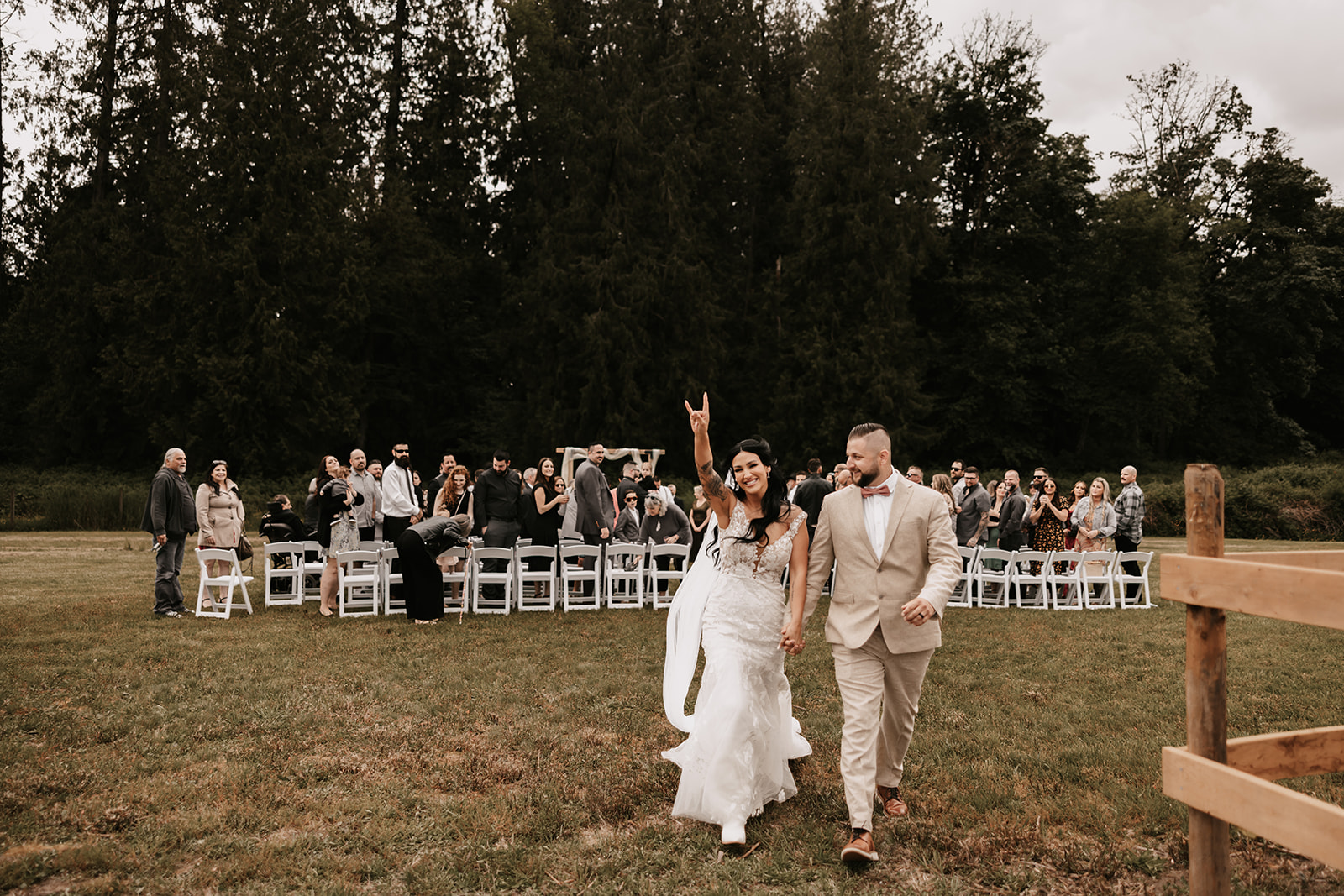 The newlyweds walking down the aisle, celebrating their marriage with a fun, rock-and-roll gesture. Knowing how to enjoy your wedding day is about embracing the joy, being yourselves, and having fun with every moment