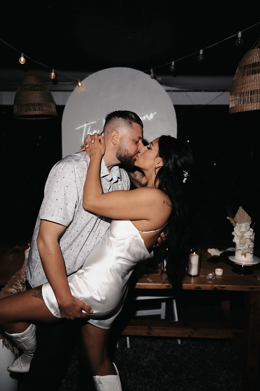 Bride and groom in a playful pose at their wedding, sharing a fun, romantic kiss during their reception. Their carefree attitude is a perfect example of how to enjoy your wedding day by keeping the atmosphere lighthearted and spontaneous.