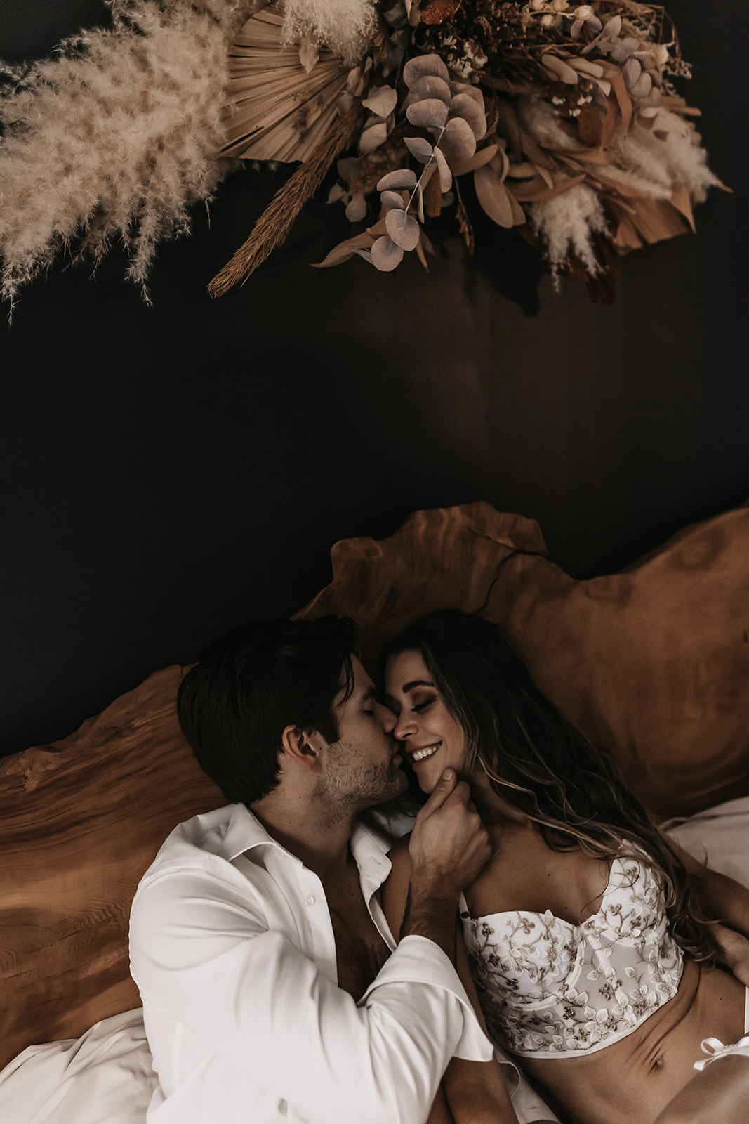 A cozy, playful moment in the bedroom between a couple, embracing the intimacy and fun energy for unique engagement photo ideas.