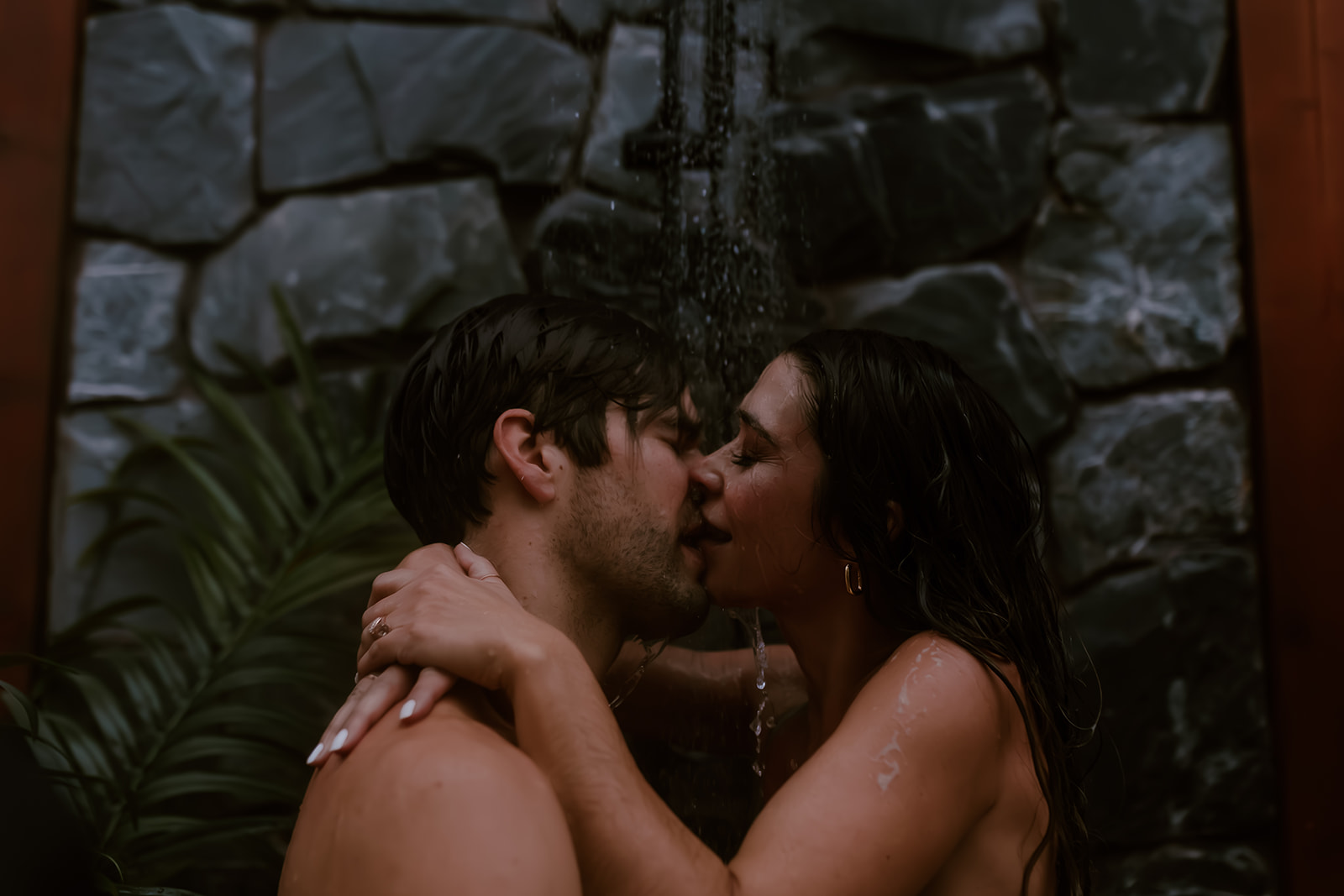 Couple kissing eachother as they take an outdoor shower