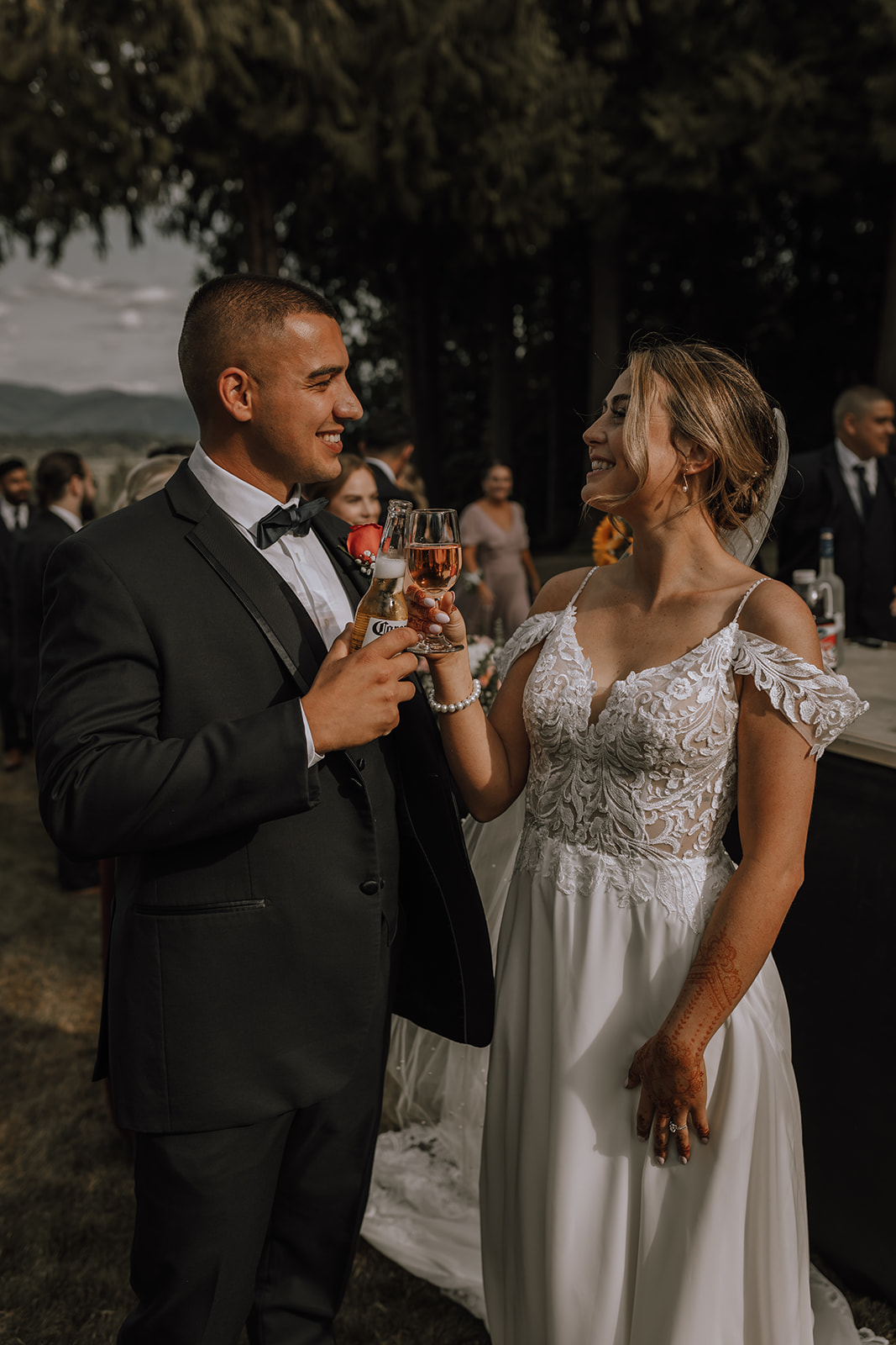 Bride and groom clinking glasses during a celebration at their backyard wedding, enjoying a quiet and joyful moment together with loved ones.