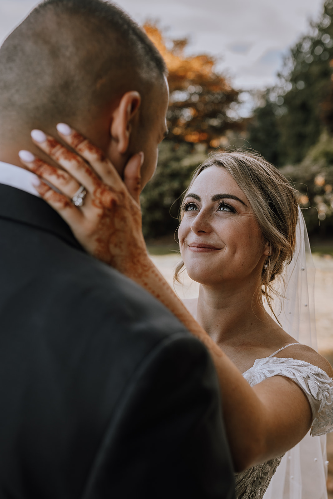 A heartfelt moment captured at a backyard wedding, with the bride gently holding her groom's face, creating an intimate and emotional memory.