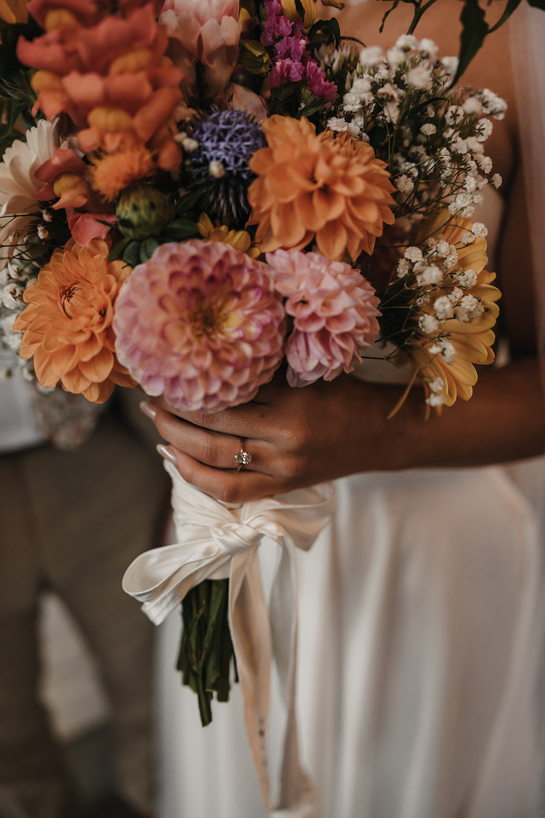 Close-up of the bride’s hands holding her colorful bouquet, highlighting how a stress-free wedding day allows you to focus on the beauty of the details.