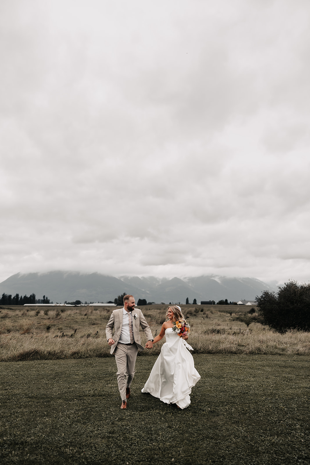 The couple strolls hand-in-hand through the fields, enjoying their time together as newlyweds. This carefree moment is the epitome of a stress-free wedding day.