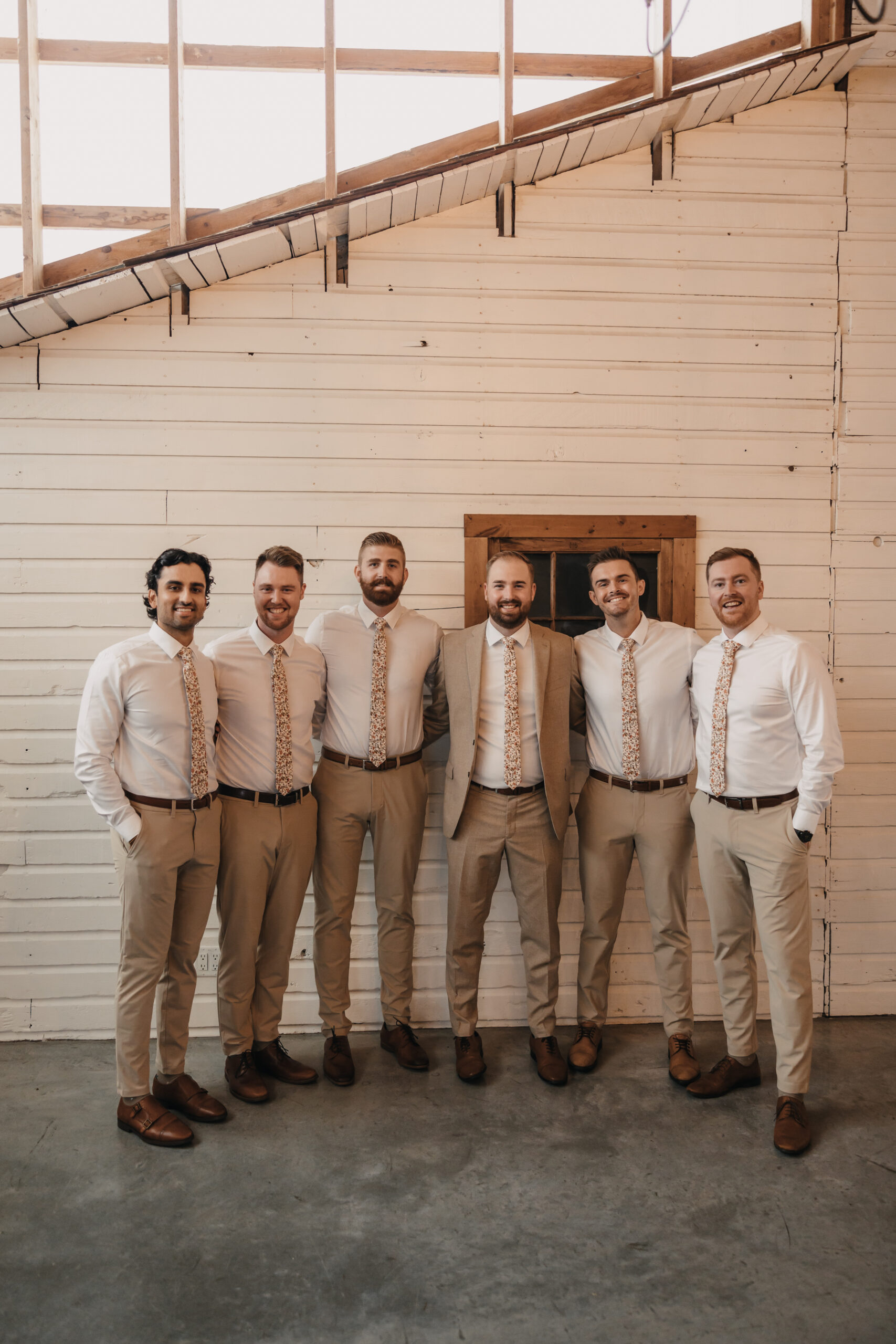 groom and groomsmen posing in a barn