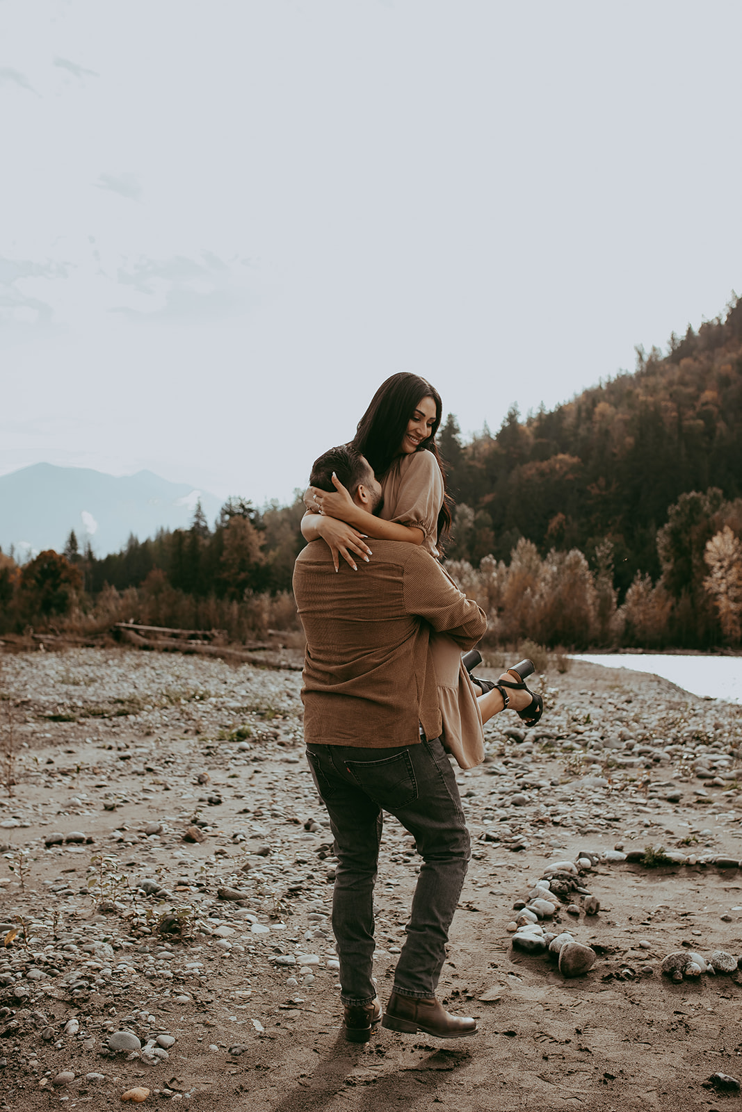 Sweet and candid moment of a couple during their engagement session, sharing a smile as they enjoy each other’s company in nature.