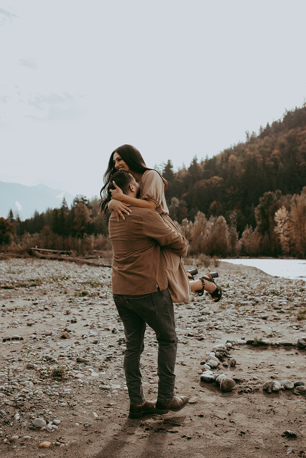 Engagement session photo of a couple holding each other and sharing a quiet, romantic moment in the middle of a rocky landscape.