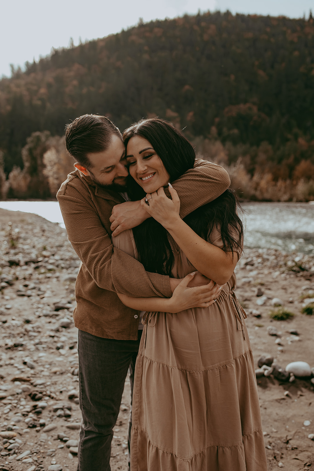 A joyful couple embracing in the middle of an engagement session with one partner lifting the other, showing love and excitement.