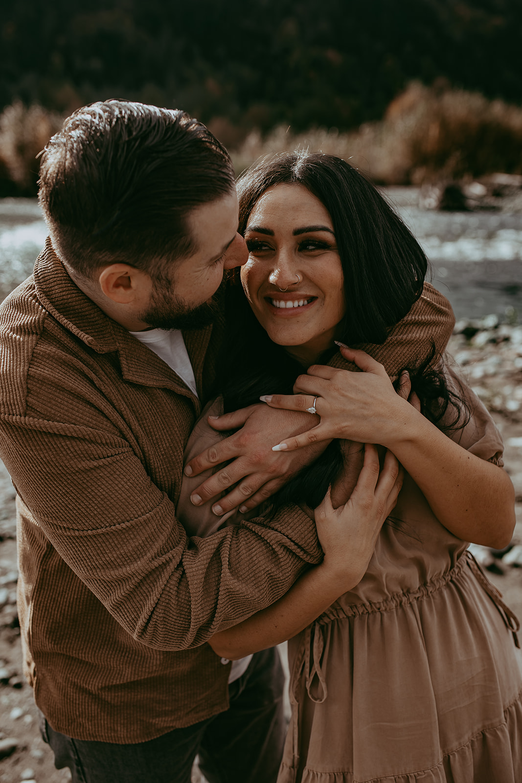 A joyful couple embracing in the middle of an engagement session with one partner lifting the other, showing love and excitement.