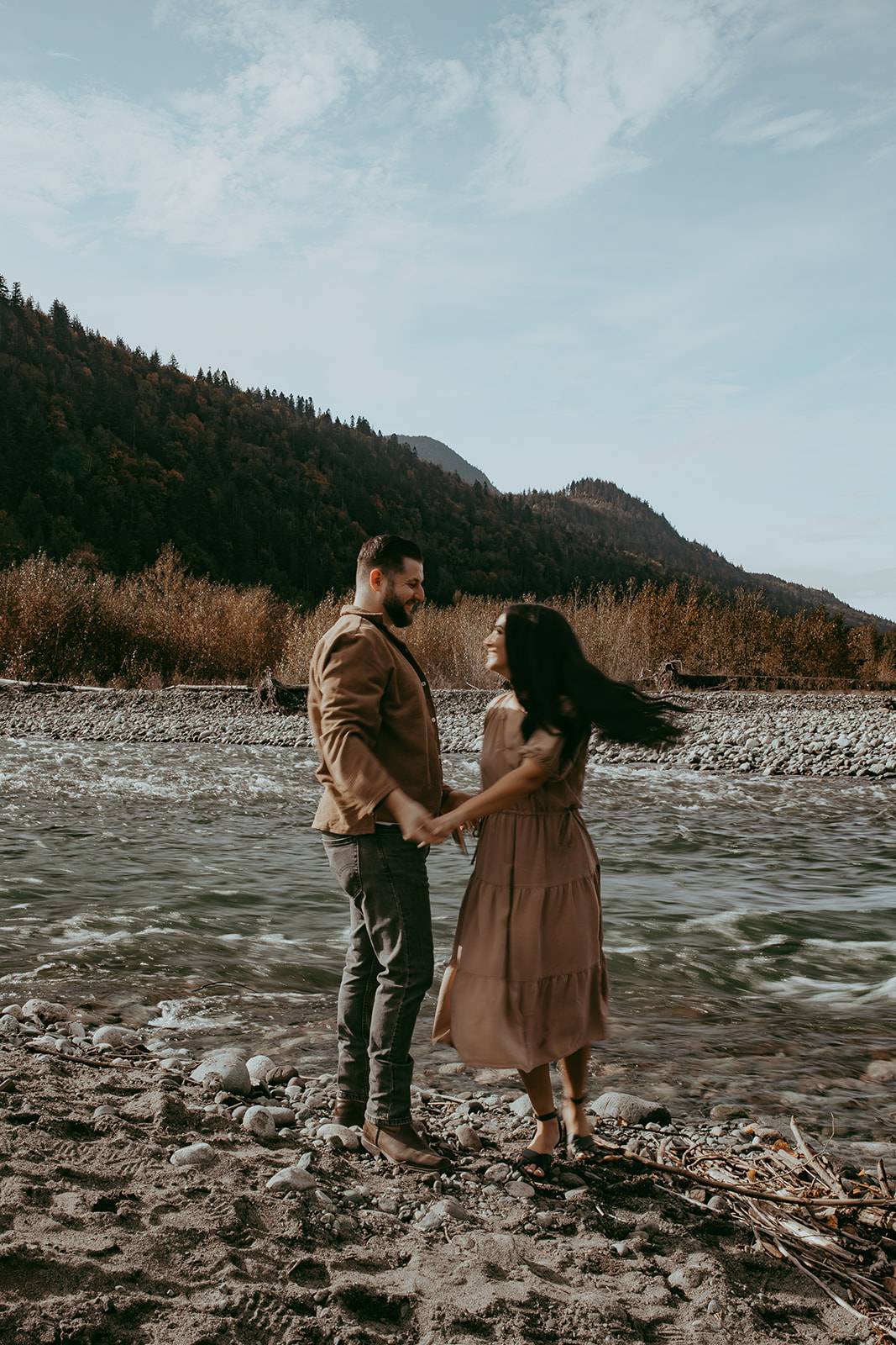 A candid moment from an engagement session as the couple twirls in the wilderness, laughing and enjoying the spontaneity of the moment.