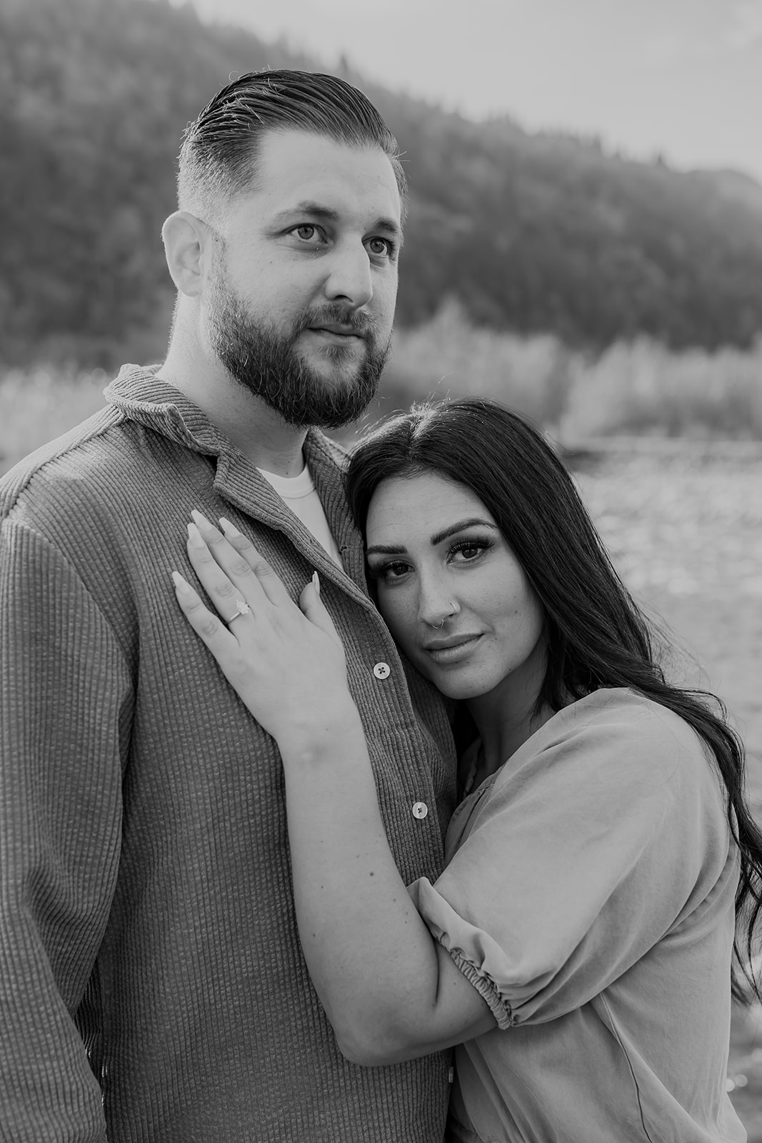 A sweet moment of connection in an engagement session with the couple sharing a close hug, looking at each other with smiles.