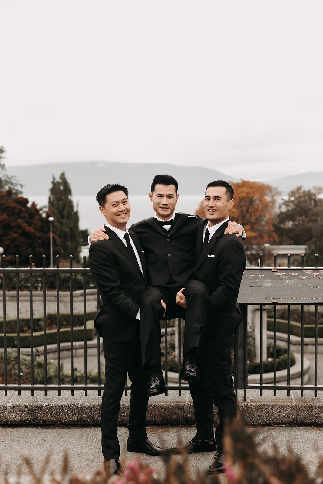 The groom and his groomsmen striking a playful pose, part of the laid-back vibe that couples can incorporate into their wedding day timeline to ensure fun moments.