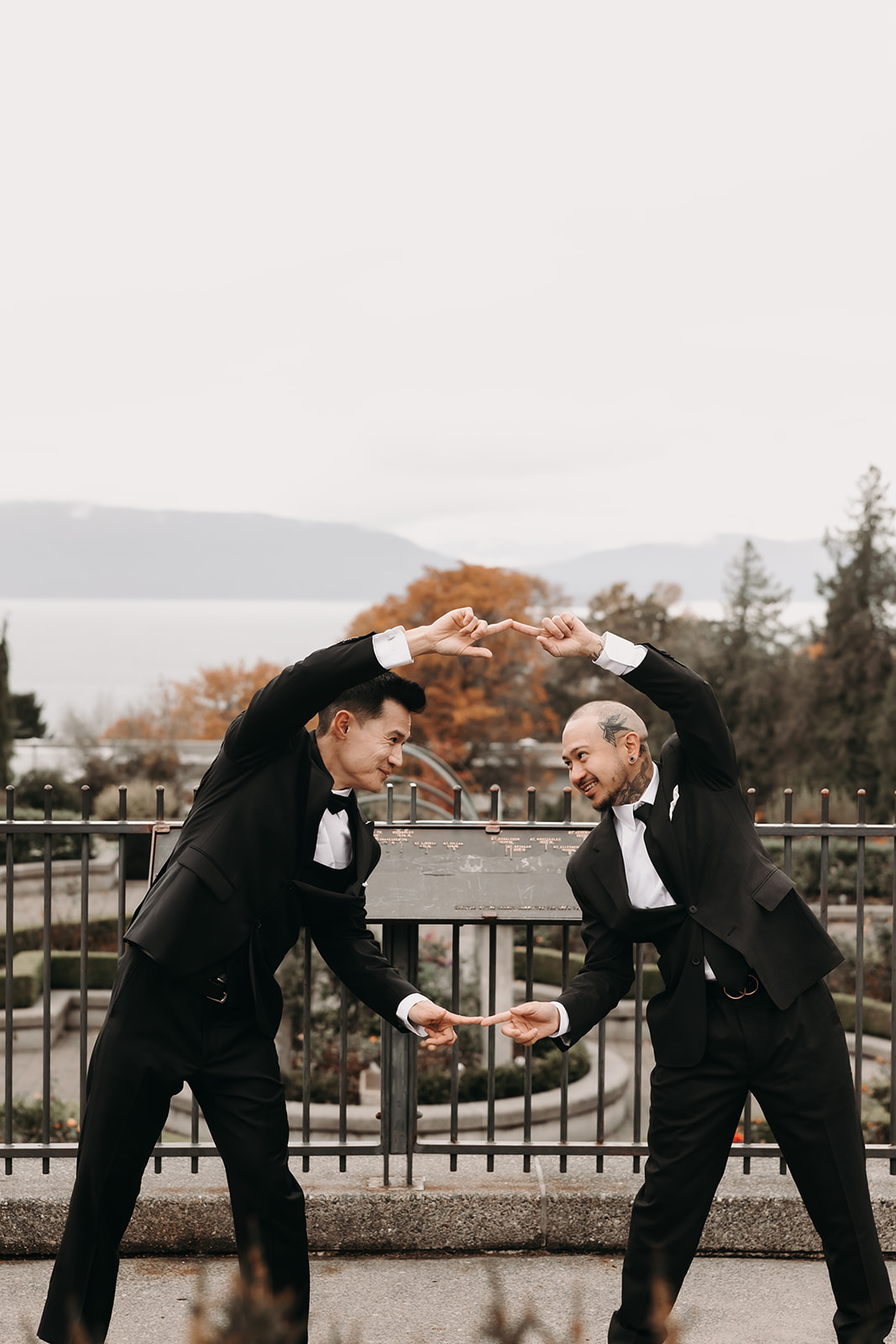 Groom with his groomsmen playfully posing with arms in the shape of a heart. They’re having fun at their Vancouver wedding at a scenic outdoor venue.