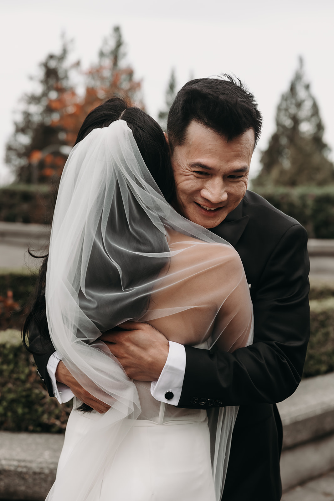 First look moment between bride and groom in Vancouver’s botanical garden. The groom’s joyful expression is captured as the bride walks toward him.