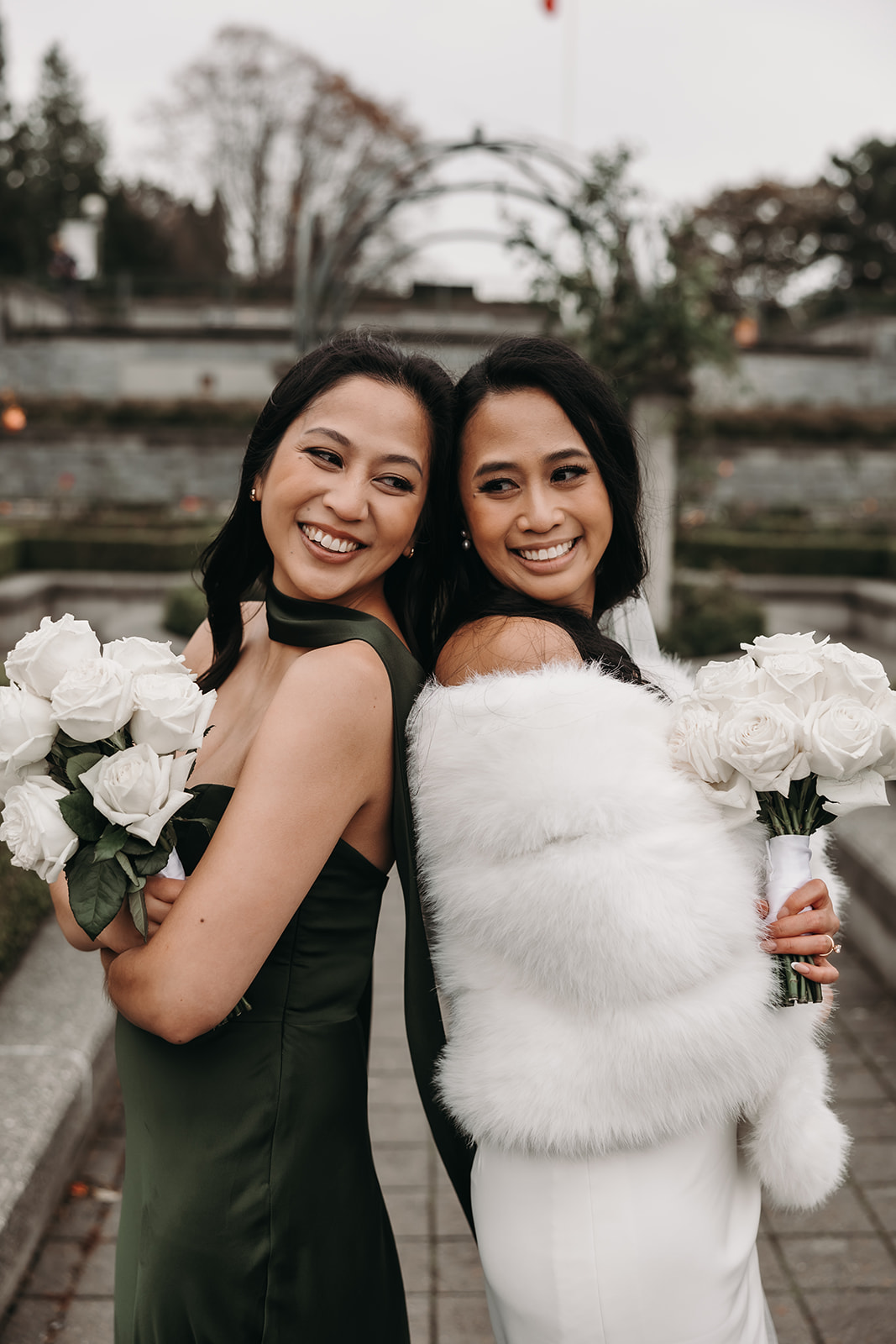 Wedding Day Timeline tips often highlight the significance of meaningful moments between the bride and her closest friends. This image captures a heartwarming moment of two women sharing smiles and excitement as they stand together before the ceremony.