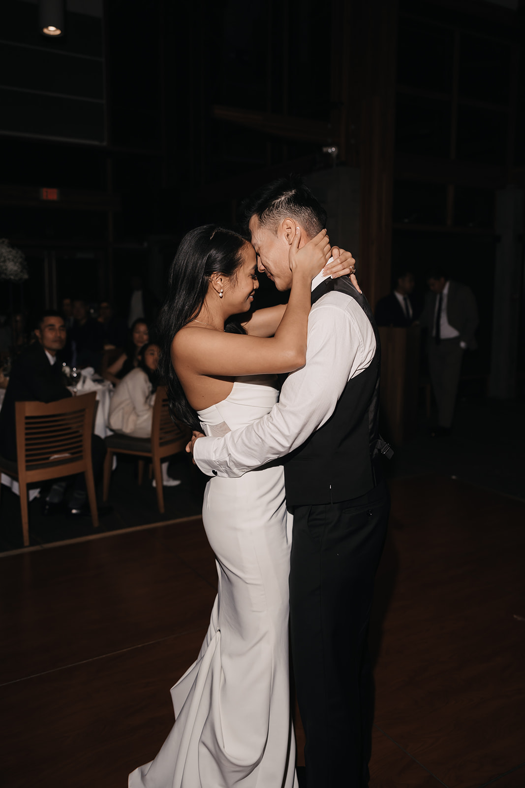 The bride and groom share a tender moment dancing at their reception, eyes locked in an intimate embrace. Their love radiates through the Wedding Day Timeline.