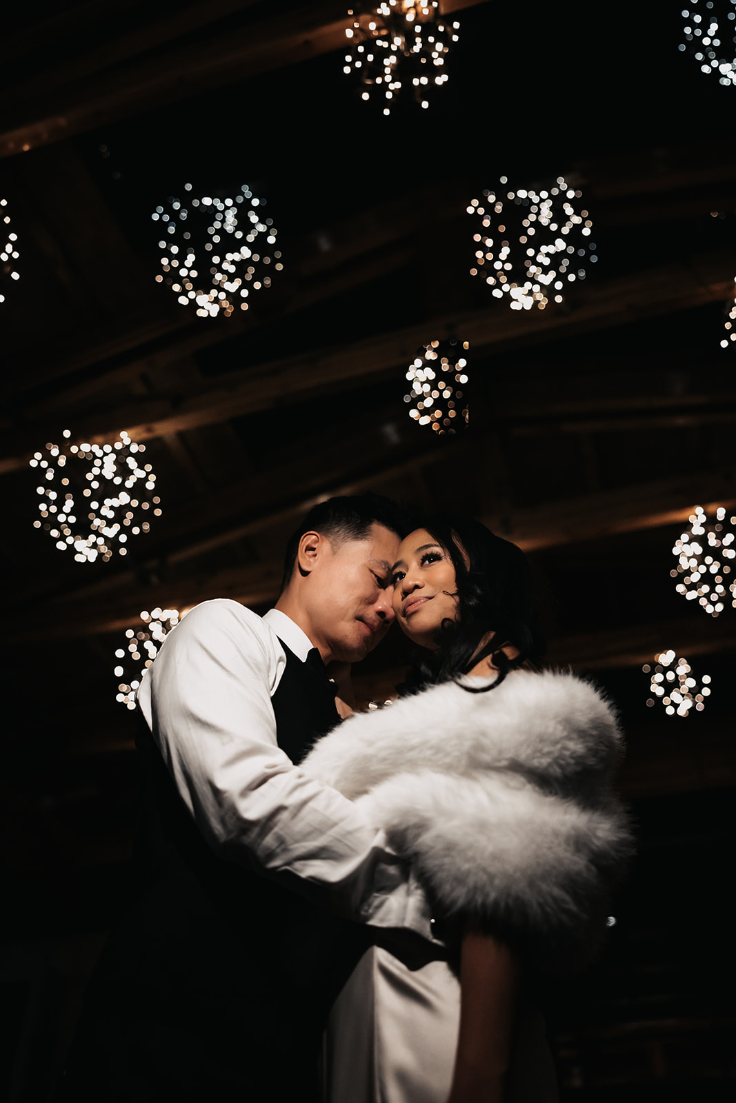 A romantic close-up of the bride and groom on the dance floor with a backdrop of fairy lights. This shot captures a special, unforgettable moment in their Wedding Day Timeline.